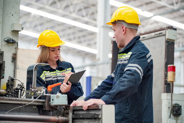 Industrial worker indoors in factory. Young technician with orange hard hat. Smart Caucasian factory worker wearing hardhat and working in power plant.