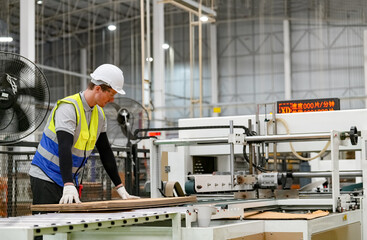 Industrial worker indoors in factory. Young technician with orange hard hat. Smart Caucasian factory worker wearing hardhat and working in power plant.