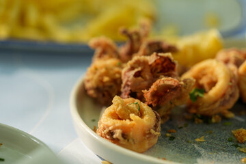 squids. fried calamari. seafood cooked and served at a restaurant. detail.