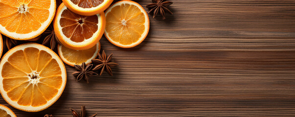 Obraz na płótnie Canvas Orange slices with spices are served on a wooden background. Rustic banner with copy space for text.