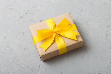Wrapped christmas or other holiday handmade present in craft paper with colored ribbon. Present...