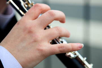  close-up of the hands of a street musician playing the flute