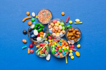 Fototapeta na wymiar different colored round candy in bowl and jars. Top view of large variety sweets and candies with copy space