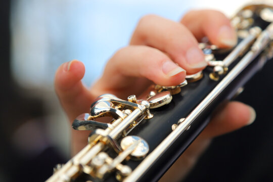  close-up of the hands of a street musician playing the flute