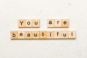 You are beautiful word written on wood block. You are beautiful text on cement table for your...