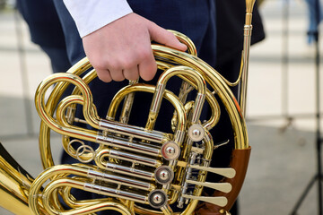 cool shots of the hands of a street musician holding a French horn