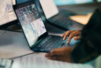 Hands typing, laptop and closeup on table of military intelligence, map and research on internet....