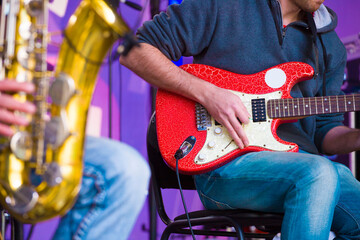 a musician plays an electric guitar on a stage - Powered by Adobe