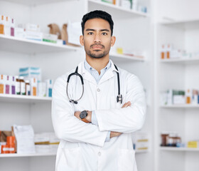 Pharmacist, man and arms crossed for healthcare service, medicine inventory and store management. Professional portrait of medical worker or asian doctor in pharmacy or clinic, pills or product shelf