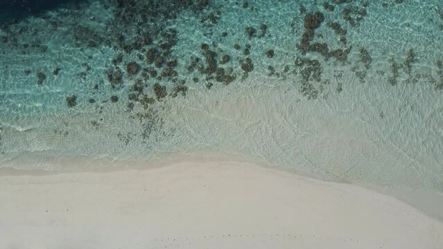 Beautiful maldives tropical island - View of the waves from above. 4K Video.