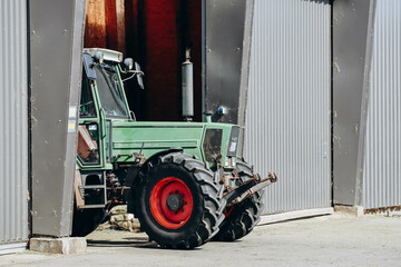 Schwangau, Germany - August 12, 2023: Tractor on the farm, half out of the hangar