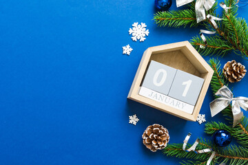 Christmas calendar 1 january. Christmas gift, fir branches, pine cones. Flat lay, top view. New Year decorations on a colored background