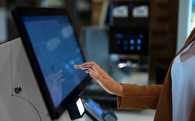 Woman pays at self-checkouts in supermarket. - obrazy, fototapety, plakaty