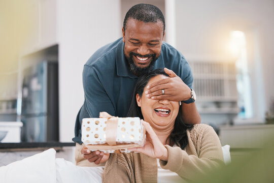 Birthday Gift Surprise, Cover Eyes And Couple Smile, Woman And Black Man Giving Package For Love, Anniversary Or Gratitude. Living Room Couch, Marriage And Home People Happy For Present Box