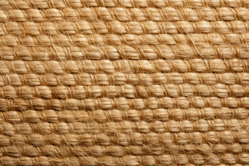 Revealing the mesmerizing artistry of handcrafted sisal weaving: an enchanting close-up capture unveiling intricate patterns and fine details in organic, textured fibers.