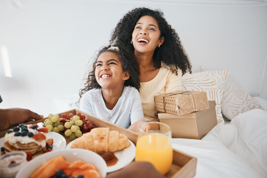 Breakfast, mothers day and child with mom in bed to relax for eating healthy, nutrition and diet. Happy, smile and young woman with girl kid in bedroom with gifts, presents and food at family home.