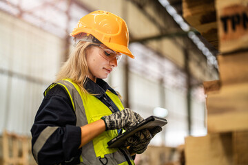 woman worker carpenter wearing safety uniform and hard hat working and checking the quality of...