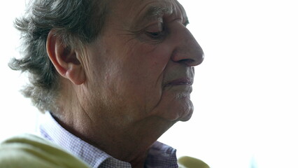 Anxious senior man close-up face biting lips feeling distressed while contemplating decision,...