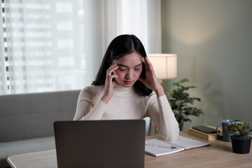 Asian young woman having trouble stress in front of a laptop