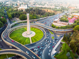 Tbilisi, Georgia - 15th july, 2022: aerial view automobiles in traffic on roundabout in Tbilisi center. Square of heroes monument