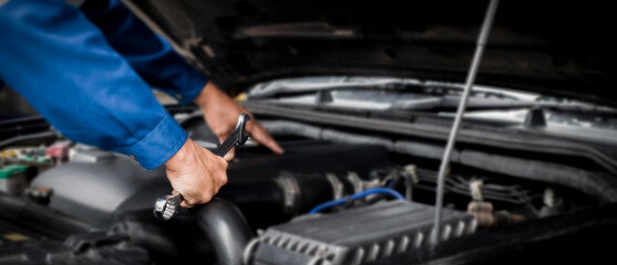 Car mechanic working on car engine, car maintenance concept.