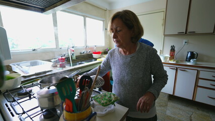 Elderly Couple Cooking Together - Authentic Family Moment in Kitchen with Senior Man and Woman...