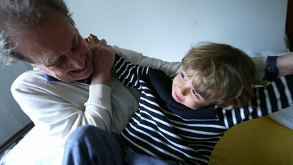 Grandfather and grandchild bonding together, senior man hugging and playing with grandson. Quality time, family lifestyle scene