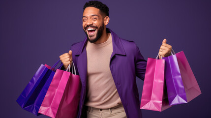 Happy smiling man holding shopping bags on purple background