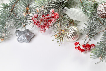 Christmas card with fir branches, viburnum berries covered with hoarfrost, and Christmas decorations. Copy space