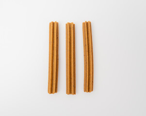 Dog chewing sticks on a white background. Treats for dogs.