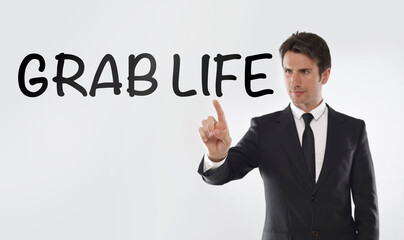 Man touching on a touchscreen with “Grab life" text	

