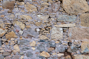 Muro de piedras de tamaños y colores variados y mortero