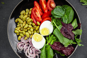 fresh salad edamame bean vegetable tomato, boiled egg meal food snack on the table copy space food background rustic top view  diet vegetarian vegan  