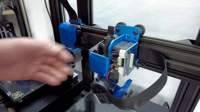 Close-up video of a technician repairing 3D printers.