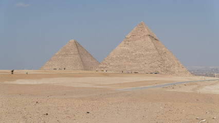 Aerial and frontal view of the Pyramids of Giza, including Cheops, Chephren and Mykerinos in the middle of the desert. In the background is seen the city of cairo or giza of egypt. 