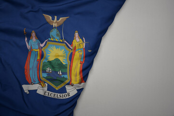 big waving national colorful flag of new york state on the gray background.