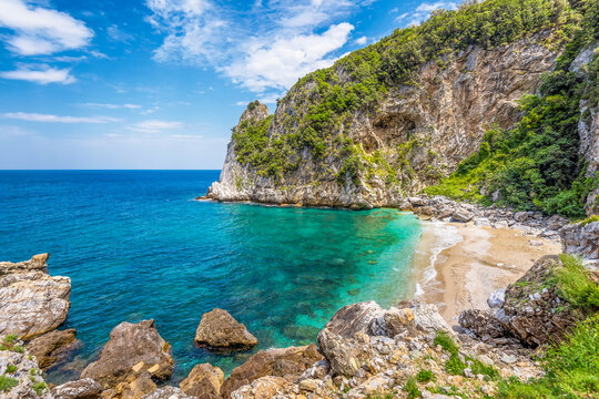 Scenic view of Fakistra beach in Pelion in Greece with the emerald water of the Aegean sea and a summer day dramatic sky