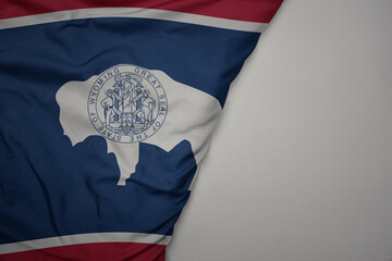 big waving national colorful flag of wyoming state on the gray background.