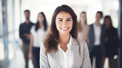 Fototapeta premium happy businesswoman standing with her arms crossed in front of a business team at the office