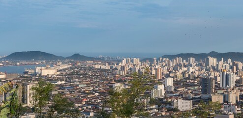 Obraz premium City of Santos, Brazil. panorama of the city and the harbor channel. In the background, the city of Guarujá. View from the top of Serrat Mountain.