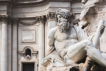 Close-up detail of biblical figure in Bernini's sculpted Baroque Fountain of the Four Rivers in Piazza Navona, a popular tourist landmark in the historic old town of Rome, Italy.