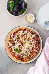 Plum cake with almond flakes, top view on the table with dessert, summer cake with seasonal fruits
