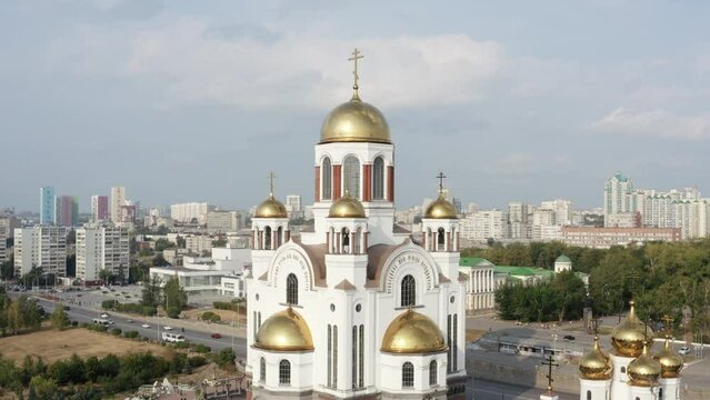 Orthodox white church building with golden domes outdoors. tock footage. Christianity religion, cathedral or temple with the big summer city on the background.