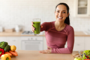 Fitness Lady Offering Green Smoothie Drink At Kitchen At Home