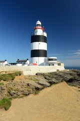 Fototapeta na wymiar The Hook head lighthouse, County Wexford, Ireland. Irish coastal landmark on a stunning September day.