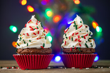 Cupcake. Cupcakes and Christmas Tree. Merry Christmas. Red cup liners. Tasty baking cupcakes, cake or muffin with white cream icing, frosting and colored sprinkles. Homemade bakery, confectionery shop