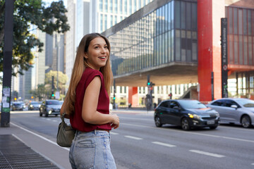 Fototapeta premium Brazilian young business woman waiting for a taxi or uber on Paulista Avenue, Sao Paulo, Brazil