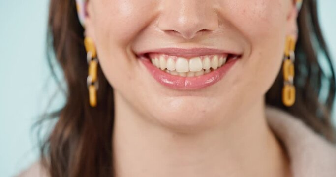 Woman, teeth and healthy smile closeup with cosmetics, dental hygiene and veneers in studio. Dentist work, female person face and happy from mouth wellness and tooth cleaning with blue background