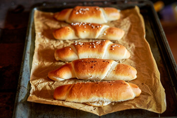 Crispy, homemade, baked, traditional czech white bread roll (rohl&iacute;k) on baking tray