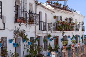 White painted houses with the  flower pots against the wall, in the beautiful mountain village of Mijas in Andalusia; Costa del Sol. - obrazy, fototapety, plakaty